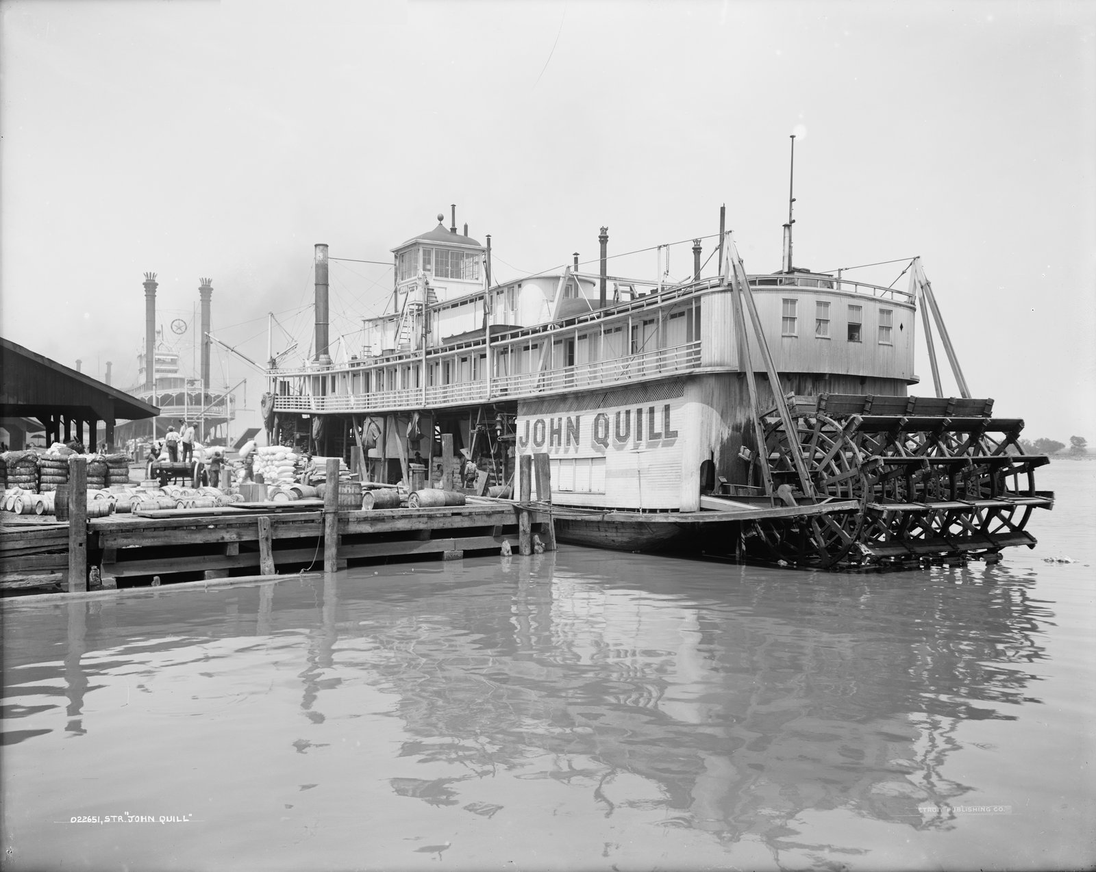 The sternwheeler John Quill moored at a wharf, seen from the stern