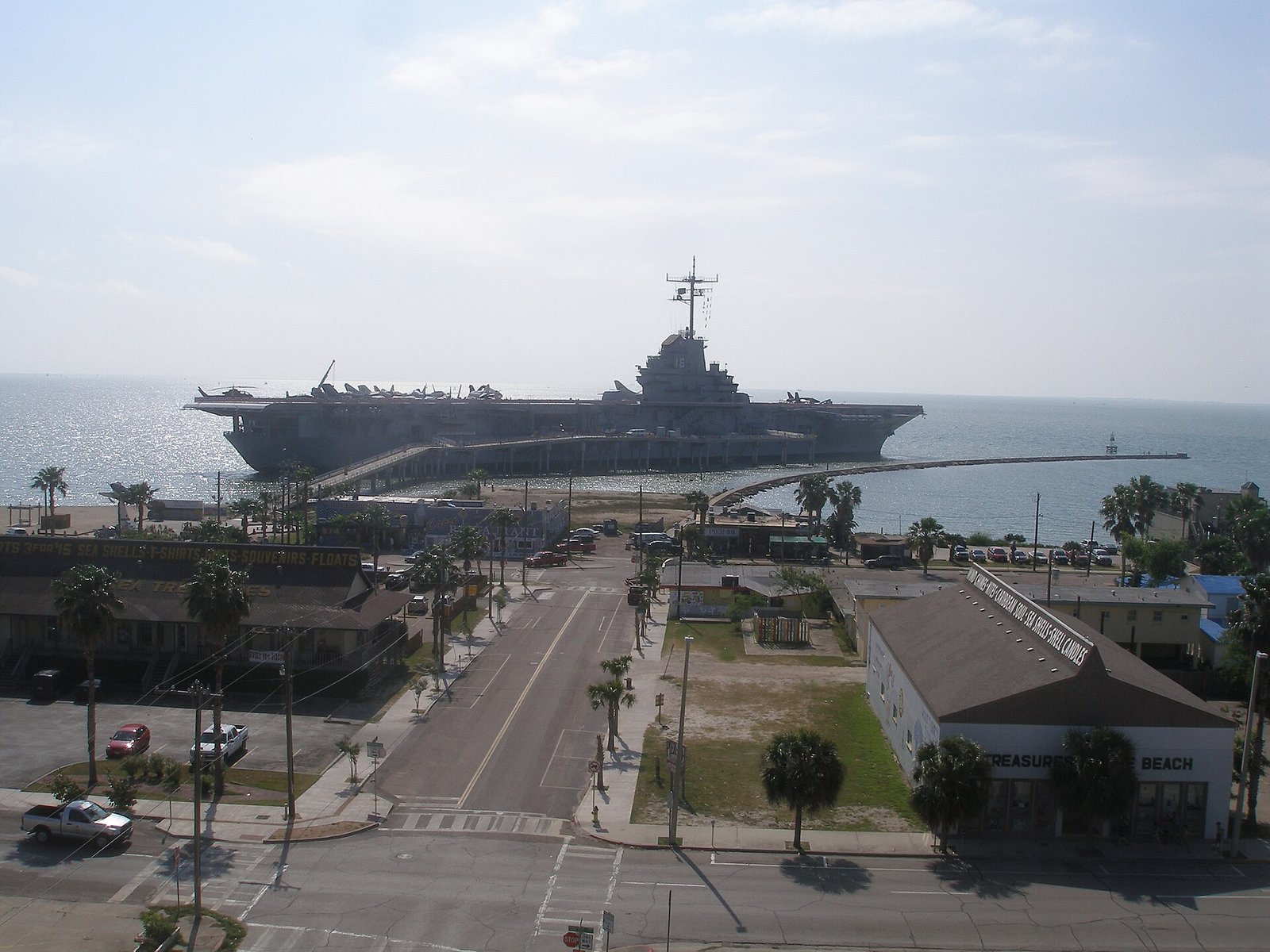View down a North Beach street toward USS Lexington moored in Corpus Christi Bay